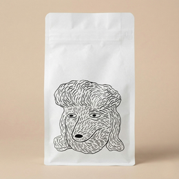 White coffee bag with a black line drawing of a dog's face on a beige background