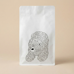 White coffee bag with a black line drawing of a dog's head on a beige background
