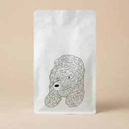 White coffee bag with a black line drawing of a dog's head on a beige background